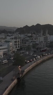Vertical Aerial Evening View of Mutrah Corniche Muscat Oman with Hajar Mountains