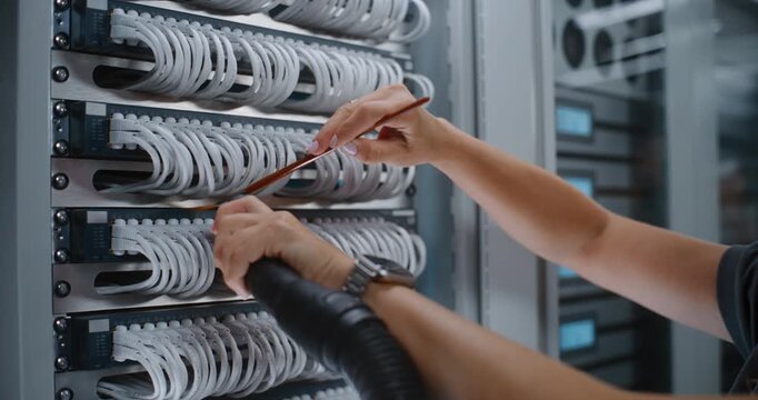 Data Center Specialist Uses Detail Brush to Sweep Dust Away From Densely Packed White Cables, Simultaneously Vacuuming to Prevent Contact Overheating and Network Signal Loss. Patch Panel Maintenance.