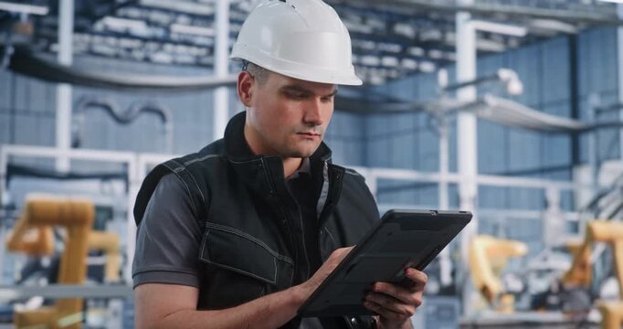 In Automated Plant, Technician Operates Digital Tablet For Diagnostic Inspection. Industrial IoT Software and Smart Devices Optimize Industry 4.0 Manufacturing Processes. Mobile Industrial Management.