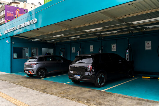 Facade of an ultra-fast electric vehicle charging station with electric cars parked in the charging bays, in the Vila Mariana neighborhood