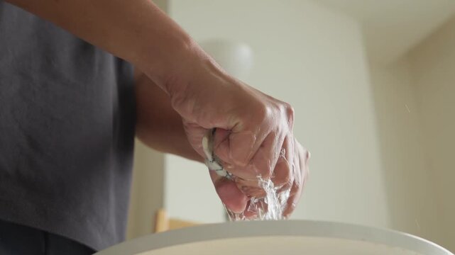Person wringing a cleaning rag during household cleaning