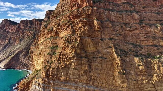 Towering Sandstone Cliff Overlooking Turquoise Cove, Climber Scouting Route From Ridge, Sheer Rock Faces,