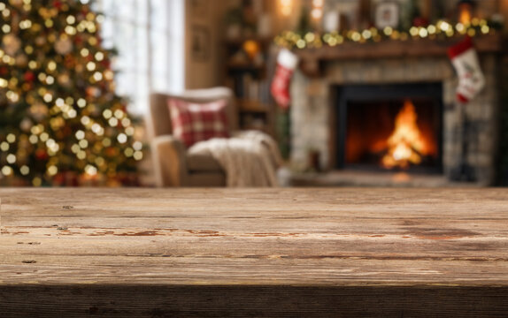 Wooden table anchors cozy Christmas decor in warm living room. Holiday setting includes lit tree, fireplace flames, hanging stockings, and soft chair by window, creating inviting festive atmosphere.