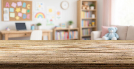 Child study area stays softly blurred behind wooden table. Kids room features laptop, books, colorful wall decor, and teddy bear, suggesting cheerful learning and play in neat space. © Agil