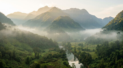 Obraz premium Winding river flowing through a misty green mountain valley at sunrise