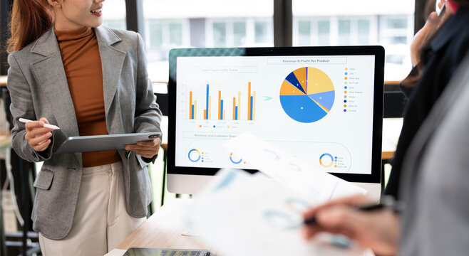 Asian Businesswoman Presenting Financial Data Report on Computer Screen