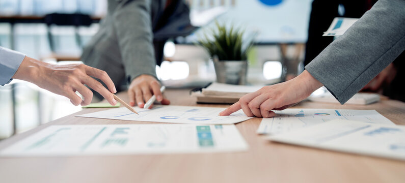 Business People Pointing at Financial Charts During Meeting
