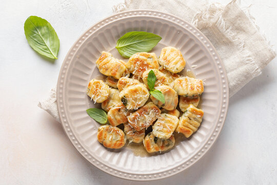 Homemade Potato Gnocchi with Basil leaves and parmesan Cheese in plate on the table