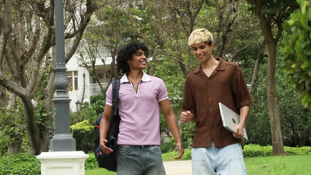Young Indian college friends walking in a park with backpacks and laptop, discussing studies and future plans, representing international education, study abroad, student life, career goals 