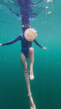 Woman snorkeling underwater with a stingless jellyfish in indonesia