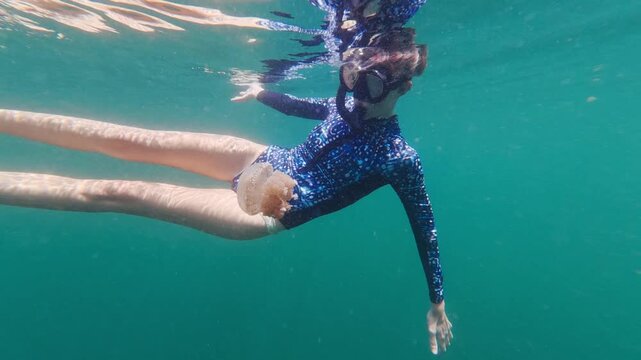Woman snorkeling underwater with stingless jellyfish in indonesia