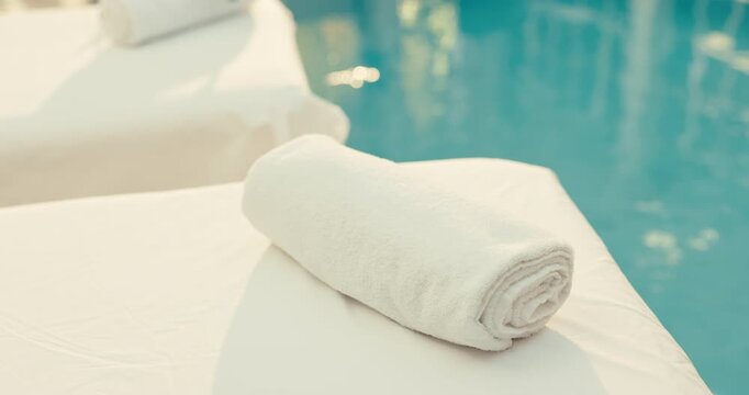 Person, hands and masseuse with towel in spa for preparation or zen on massage bed by poolside. Therapist, fabric or decor with texture cloth for relaxation, stress relief or comfort in luxury resort