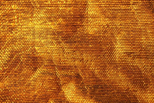Golden foil thermal insulation material background texture with quilted pattern