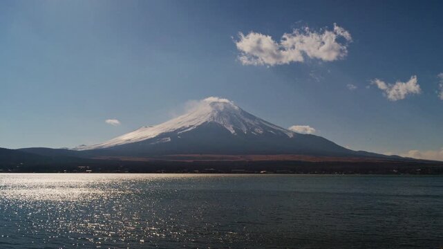 4K Scenic view of Mount Fuji covered with snow and lake in daytime under blue sky, Japan