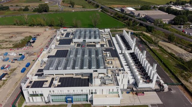 Aerial view of a large hyperscale data center campus with redundant power, Milan, Italy. Cooling, network and security infrastructure supporting cloud computing, colocation and business-critical digit