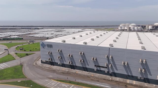 Massive vehicle storage building at the Port of Veracruz with parking lots and tanks, aerial