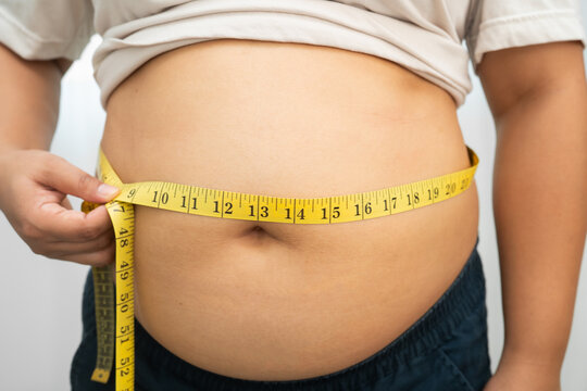 Asian woman use hand to squeeze fat belly big size overweight and obesity.