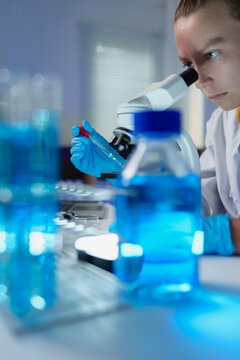 Scientist conducting research experiment with microscope in laboratory