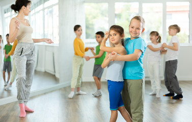 Fototapeta premium Couple boy and girl rehearsing pair waltz dance in studio