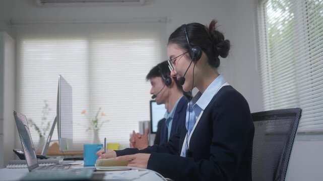 Competent call center operator team assisting customers with headsets and computers in a modern office