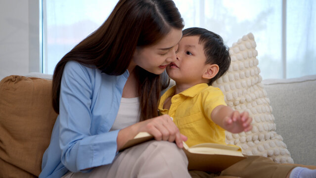 Mother reading a book with her child in a warm home setting