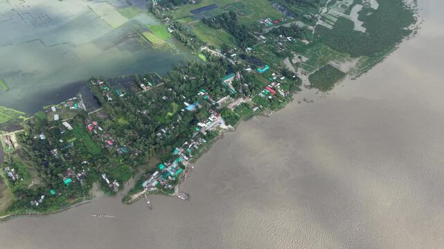 Aerial view of rural riverbank village and agricultural fields in bangladesh drone