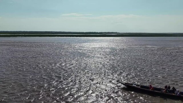 Aerial view of traditional wooden boat navigating a wide tropical river at sunset travel water nature