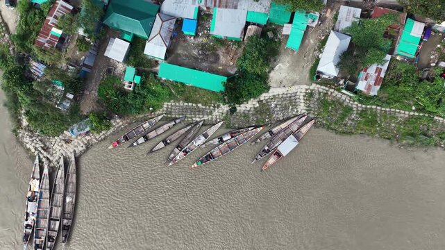 Aerial view of traditional wooden boats moored at riverside village dock in south asia drone