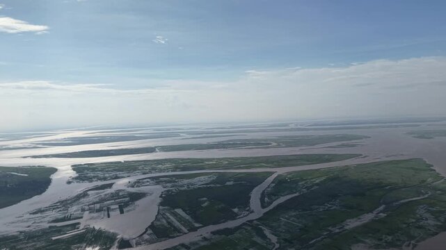 Aerial view of vast river delta and wetlands, wide landscape panorama of winding waterways and lush green islands at sunset