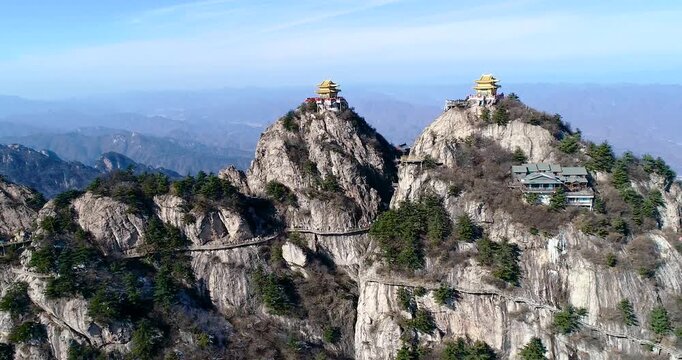 Aerial View of Two Golden Temples on Rocky Mountain Peaks with Winding Cliff Paths