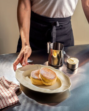 Woman Serving Japanese Souffle Pancakes on a Metal Table
