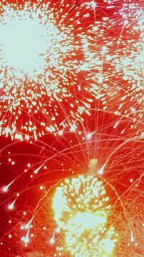 Vertical video shows fireworks display in black night sky. The composition includes abstract light pattern and visual texture against black background across the visible setting.