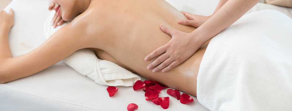 Beautiful young Asian woman receiving back oil massage