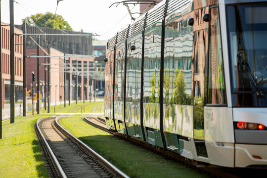 An electric line 15 tram moves on living grass-covered tracks of the Raide-Jokeri light rail past Aalto University in Otaniemi, Espoo, Finland.