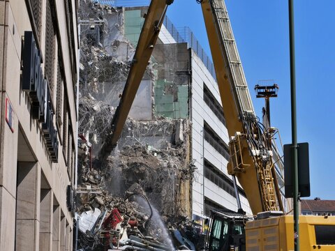 High Reach Demolition Crane and Heavy Excavator Arm Working on Urban Building Site Dismantling Concrete Structure
