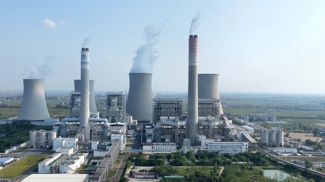 Aerial view of large thermal power plant with cooling towers and smokestacks