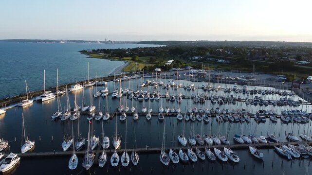 Ega Marina packed with sailboats along the Danish coast near Aarhus at evening, aerial