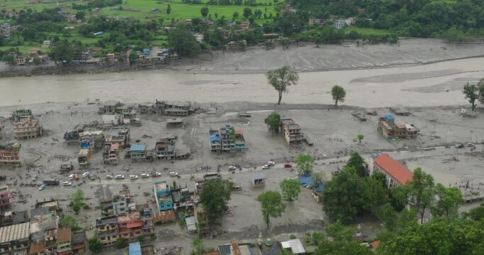 Nuwakot Nepal, aerial shot of severe post-disaster devastation with homes, roads, and infrastructure submerged in thick mud and silt along the swollen Trishuli River following a Tibet glacier outburst