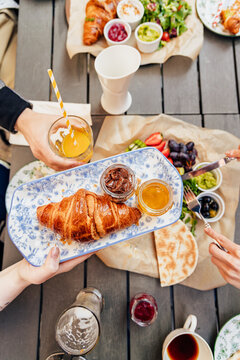 Friends sharing a delicious breakfast platter outdoors