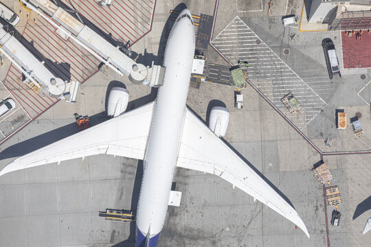 Aerial top down view of airplane at airport gate