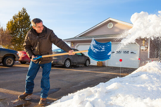 An elderly man Shovels snow in northern Alberta