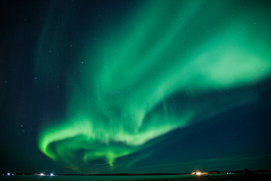 Vibrant green aurora borealis dances across the night sky