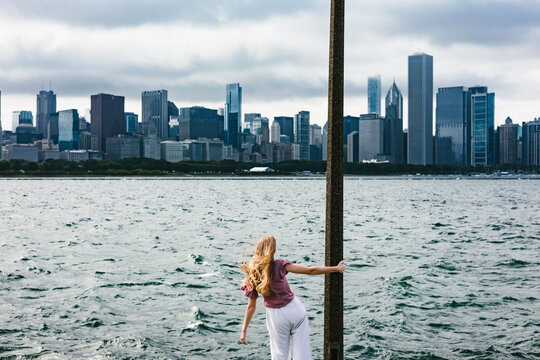 Woman with windblown hair watches Chicago skyline