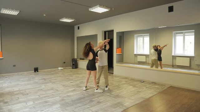Young energetic couple dancing bachata in a dance studio