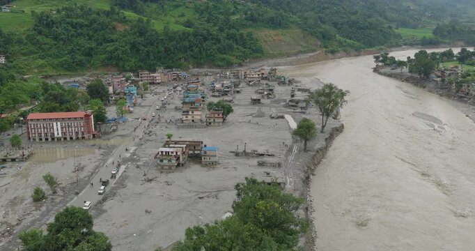 Nuwakot, Nepal, drone shot of severe flash flood destruction along the Trishuli River, of severe riverbank erosion and village infrastructure deeply buried under thick silt caused by glacier outburst