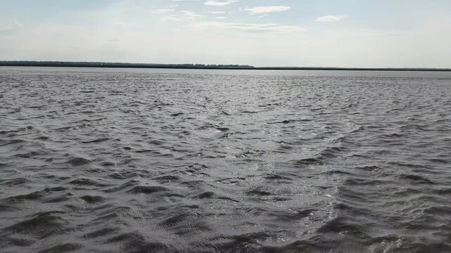 Wide river landscape with rippling water surface and distant horizon line ripples waves nature