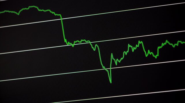 Close view of a green cryptocurrency price line plunging sharply on a dark market chart before continuing with volatile sideways movement