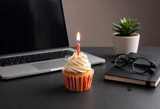 Cupcake with lit candle on modern workspace desk setup