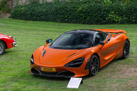 Mondorf-les-Bains, Luxembourg - September 13th 2026 : View on an orange McLaren 720S finished in Azores Orange parked on a lawn.