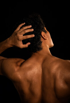 Man with hand resting on head in thoughtful pose